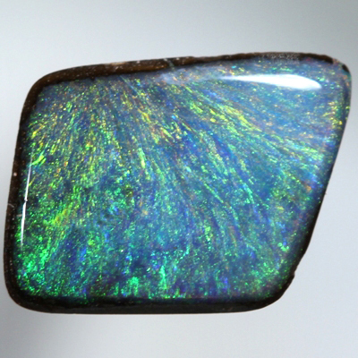 SOLID BOULDER OPAL Bright orange and green sparkles over blue